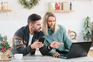A couple looking at a laptop screen together in a holiday setting