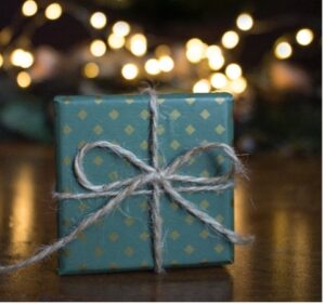 holiday-gift-wrapped-with-lights-in-background