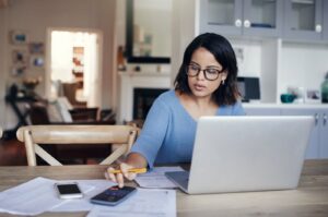 A woman managing her budget at home, representing steps to financial independence for women