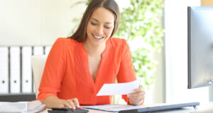 A woman smiling while reviewing her financial statements